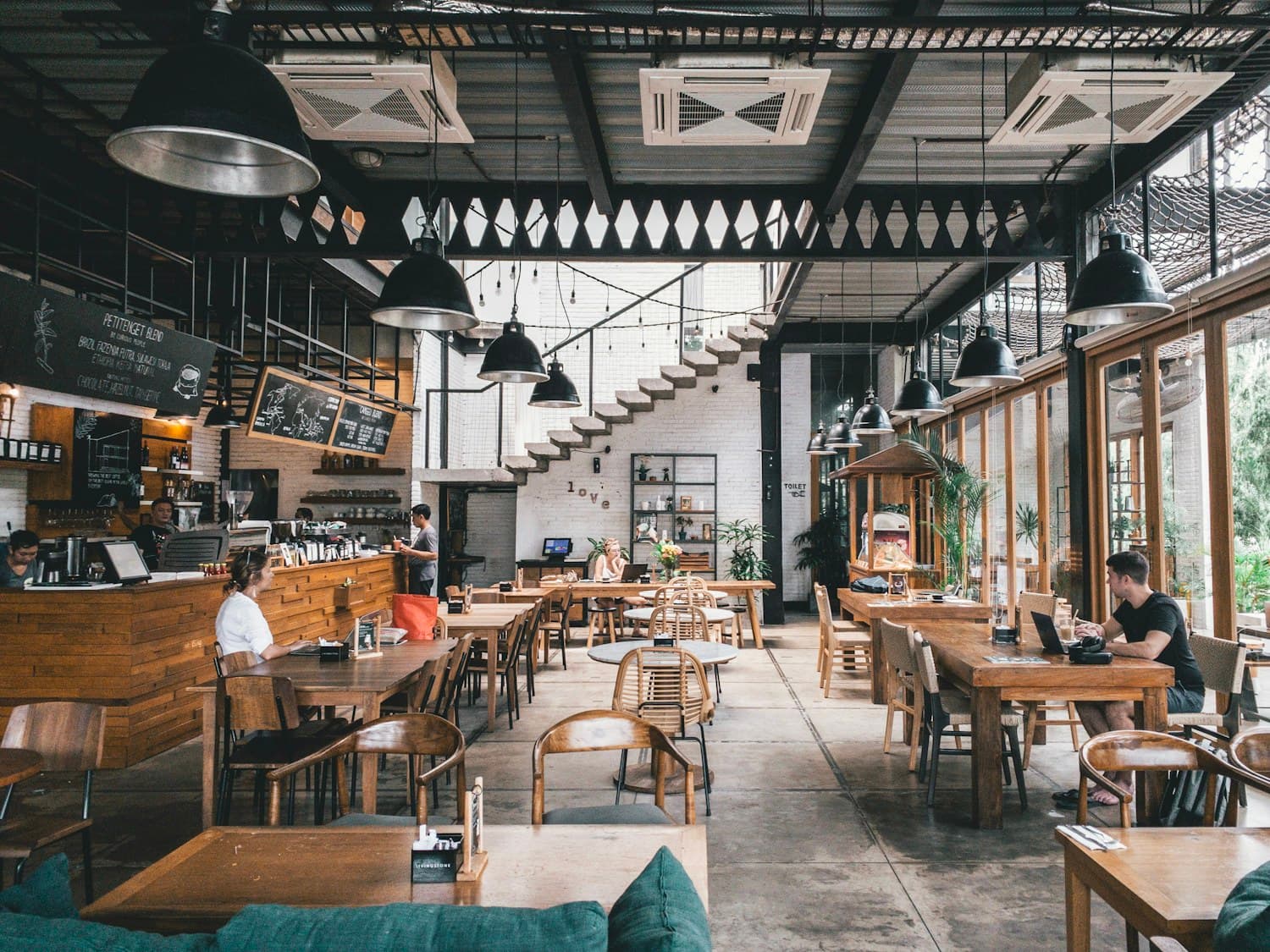 Salle chaleureuse de bistrot parisien avec banquettes et tables dressées